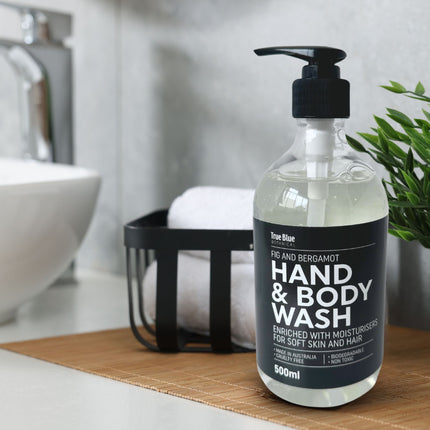 True Blue Botanical Fig and Bergamot Hand and Body Wash 500ml bottle placed on a bathroom counter with towels and greenery for a fresh, clean setting