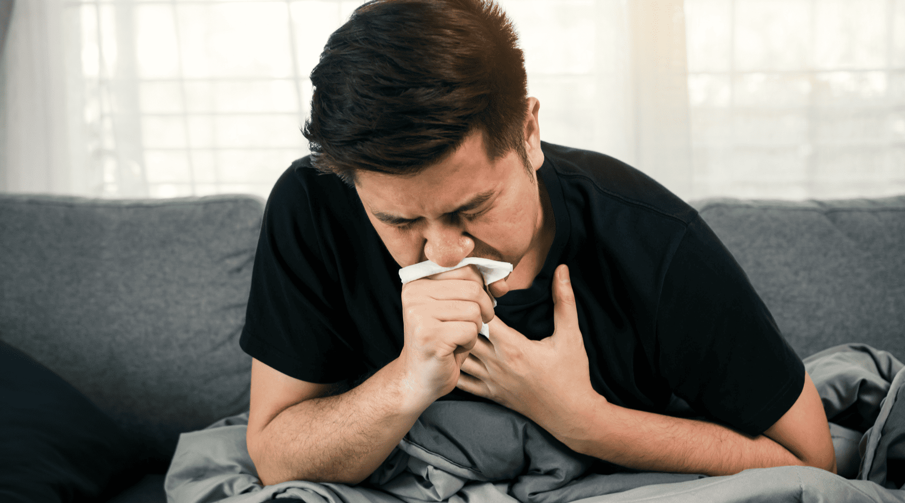Man holding chest and coughing due to illness