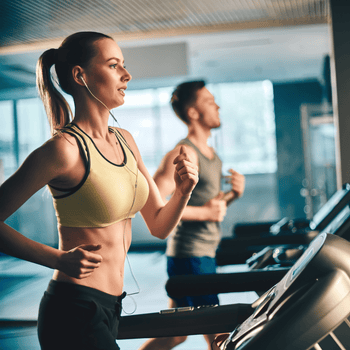 Fit man and woman doing cardio training on treadmills in a modern fitness centre