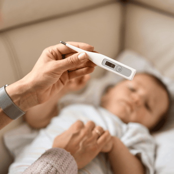 Parent checking a baby’s temperature with a digital thermometer