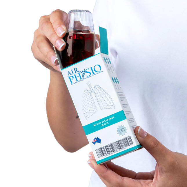 Hand holding an 'Air Physio' product packaging with a clear container filled with a red liquid.