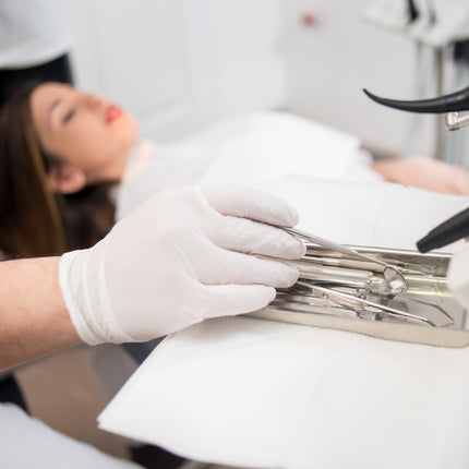 Dental professional wearing Bastion Ultra Soft white nitrile exam gloves during clinical treatment for hygienic protection