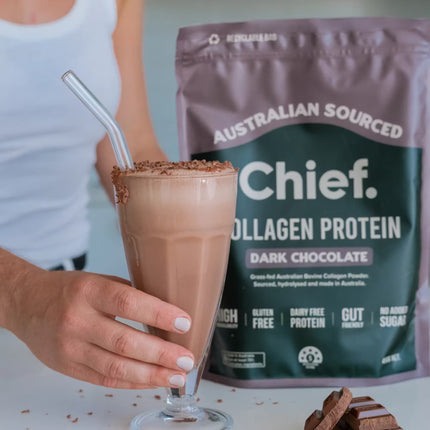 Glass of chocolate smoothie with Chief Collagen Protein Powder package in the background