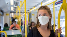 Woman wearing AMD mask in a public transport