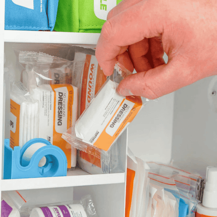Worker refilling FastAid R2 Workplace Response Metal Cabinet First Aid Kit