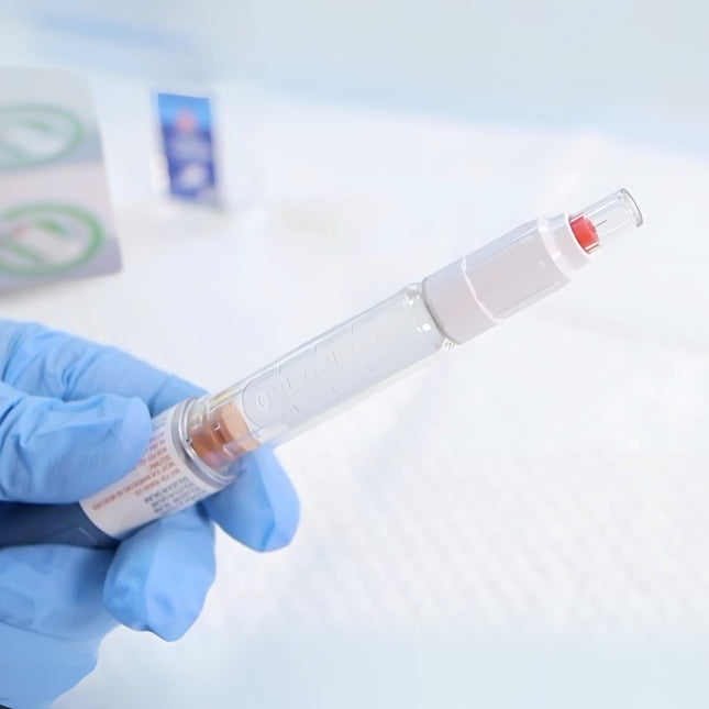 A healthcare professional holding an insulin needle pen with a drop of insulin, demonstrating safe use